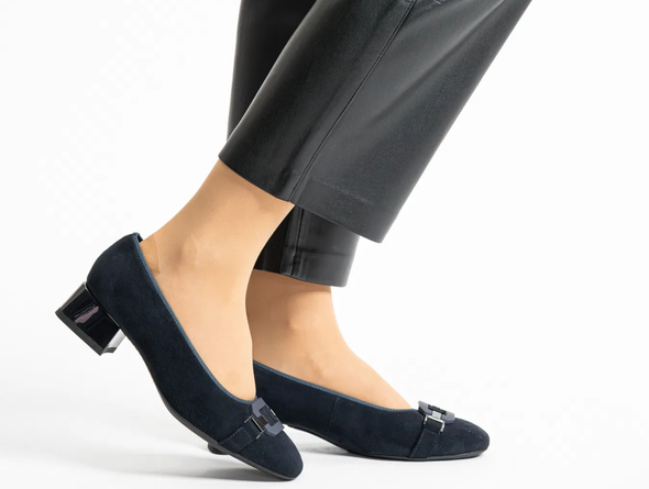 Ara 12-20430-02 Navy pumps with tonal decorative buckle, medium paragraph heel, worn with grey pants on a white background