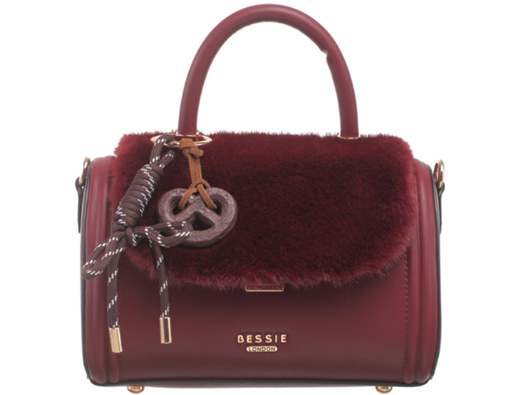 Bessie London Plush Barrel handbag in burgundy with faux fur detail and decorative pretzel charm on a white background