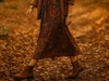 Birkenstock Highwood - Chelsea style suede ankle boot in a Dark Tea colour, worn by a lady in a paisley dress with layered clothing on a leaf covered ground. 