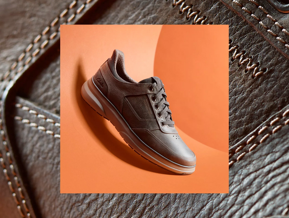 Clarks Mullan Easy - Dark Brown leather laced casual shoe against an orange background. 