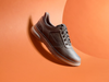 Clarks Mullan Easy - Dark Brown leather laced casual shoe against an orange background