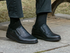 G-Comfort A-905 - Black leather shoes worn with black socks on a pavement background