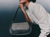 Person holding Hispanitas BI254150 Hand Bag - Black / White with houndstooth pattern and black leather sides on a dark background