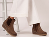 Lotus Connie GLC014 - Brown wedge ankle boot with elastic panels worn with white ides leg trousers against a light background. 