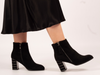 Lunar Switch GLR105 - Black zipped ankle boot with metallic accents on a medium block heel worn by a lady wearing a midi skirt against a white background