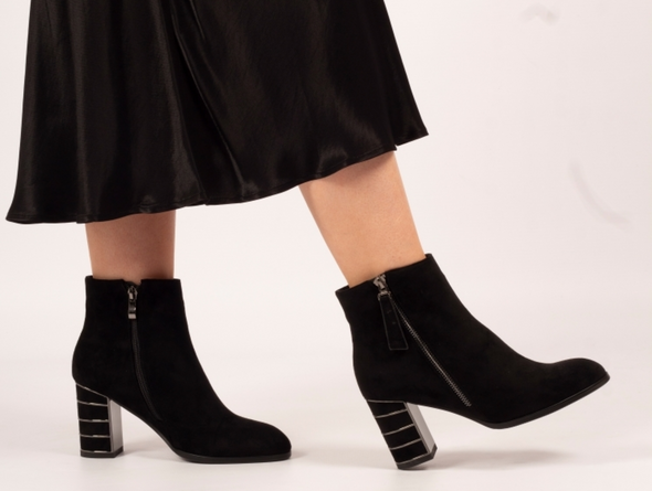 Lunar Switch GLR105 - Black zipped ankle boot with metallic accents on a medium block heel worn by a lady wearing a midi skirt against a white background