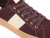 Close-up of NeroGiardini I514151D 613 - laced Burgundy sneaker  with a white patch and gold accents on a white background