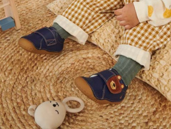 Startrite Bear Hug 0824-9 - Navy worn by a child on a wicker mat. 
