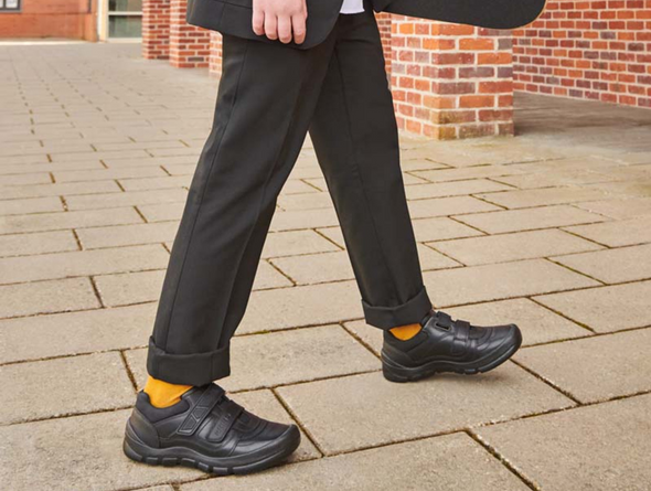 Startrite Rhino Warrior-8237-7 - Black school shoe worn by boy on pavement 